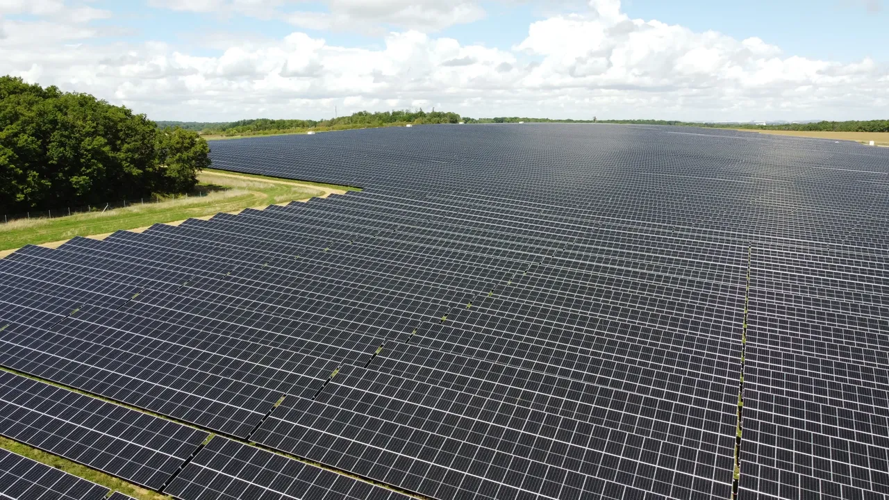 Es werden auf einem Feld nahe der Stadt Troyes in Frankreich großflächige Solarpanels mit darunter liegenden Weideflächen dargestellt.
