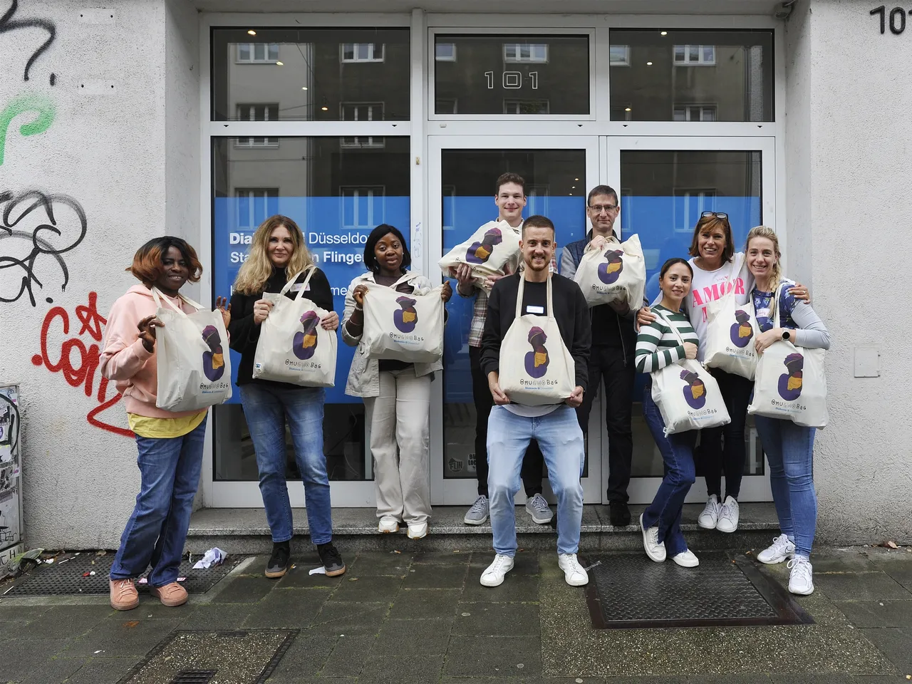 Es werden Mitarbeiterinnen und Mitarbeiter vor dem Eingang der Diakonie Düsseldorf-Flingern im Rahmen des Commerz Real Social Days 2024 in Düsseldorf dargestellt.