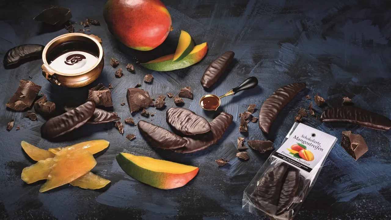Kandierte Früchte und schokoliertes Obst auf einer schwarzen Platte angerichtet