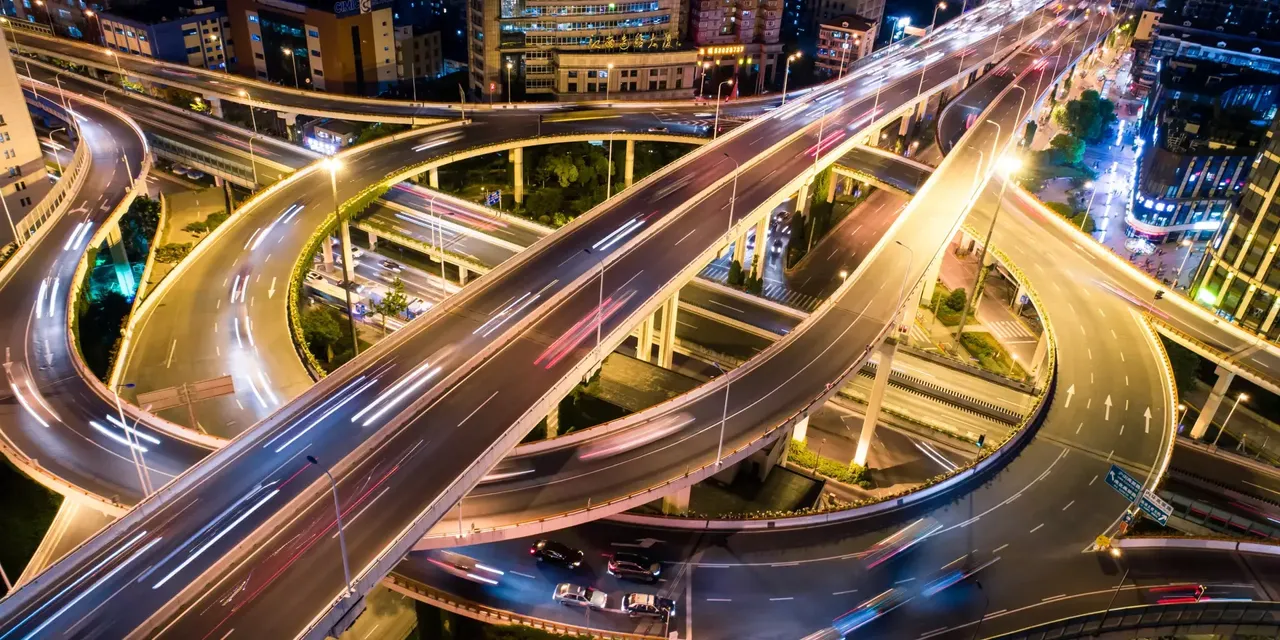 Luftaufnahme bei Nacht: Es wird ein mehrspuriger Verkehrskreisel in Shanghai