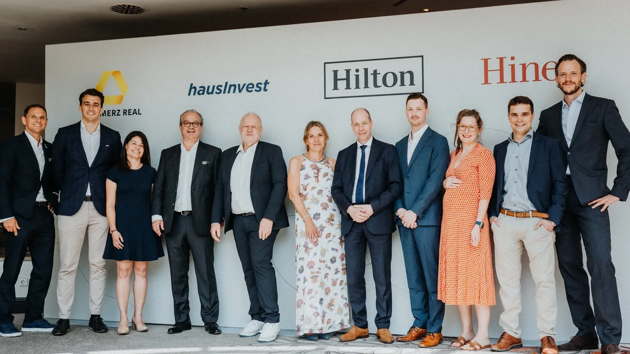 Es wird eine Gruppenbild im Rahmen der Vertragsunterzeichnung des Mietvertrages mit Hilton und der Commerz Real dargestellt.