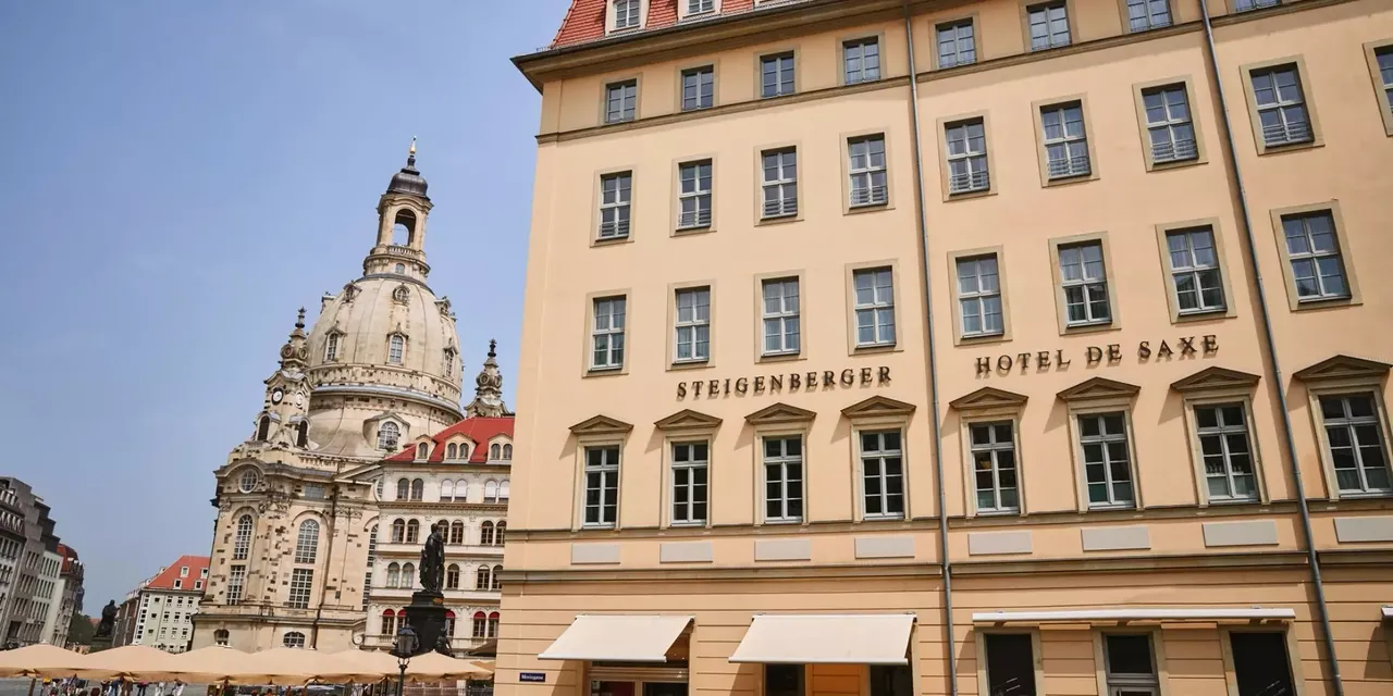 Es wird die Außenansicht der hausInvest Immobilie Hotel de Saxe in Dresden dargestellt, im Hintergrund ist die Frauenkirche zu sehen.