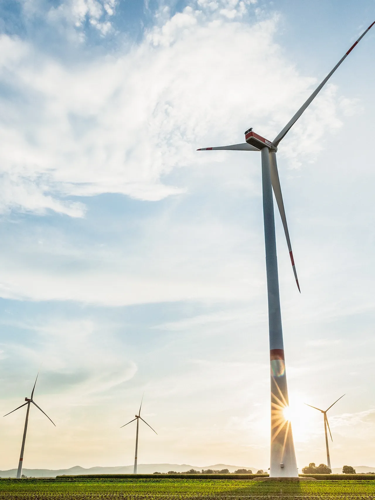 Aufnahme von fünf
  Windrädern des klimaVest-Assets Windpark Freckenfeld im Sonnenlicht.