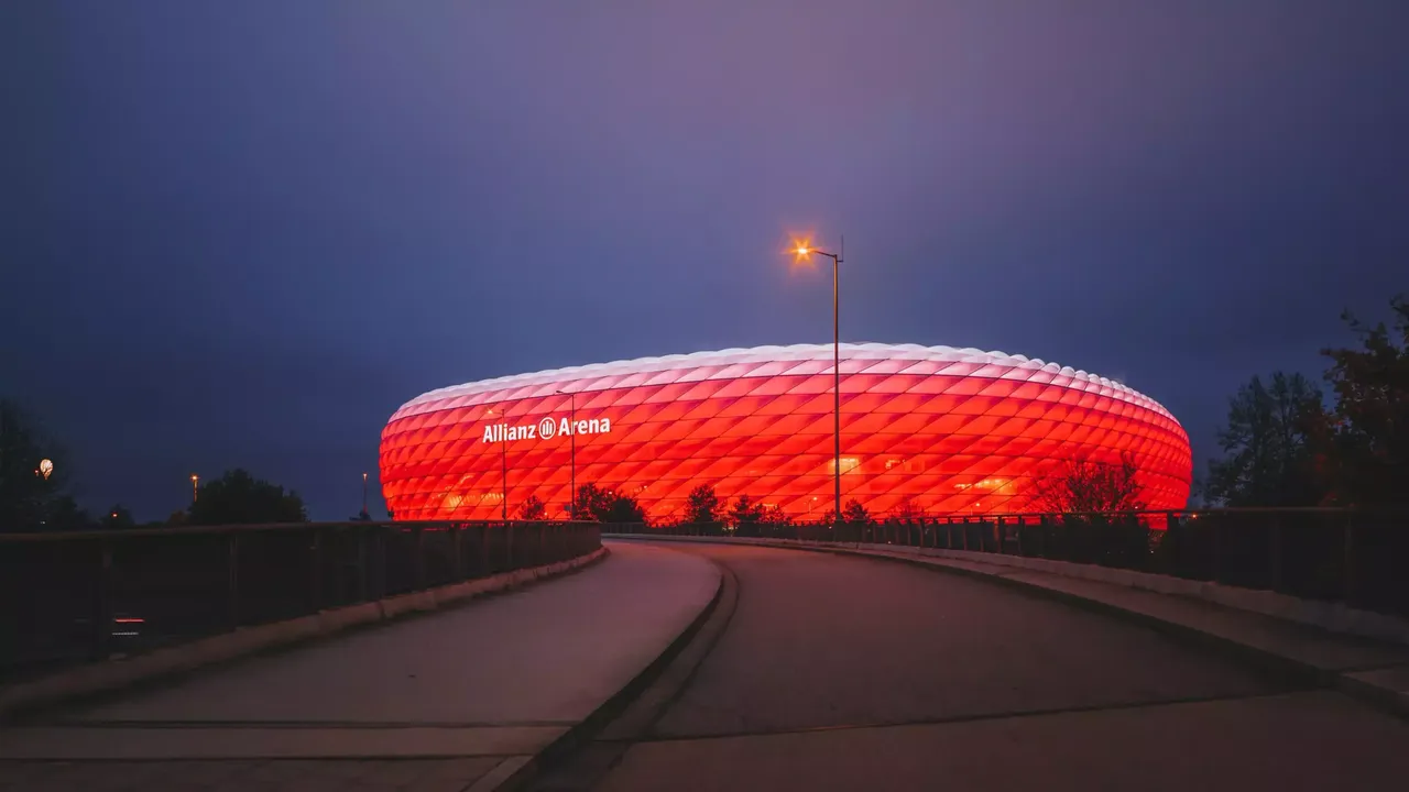 Es ist im Nachthimmel die Aussenfassade der Allianz Arena in München abgebildet.