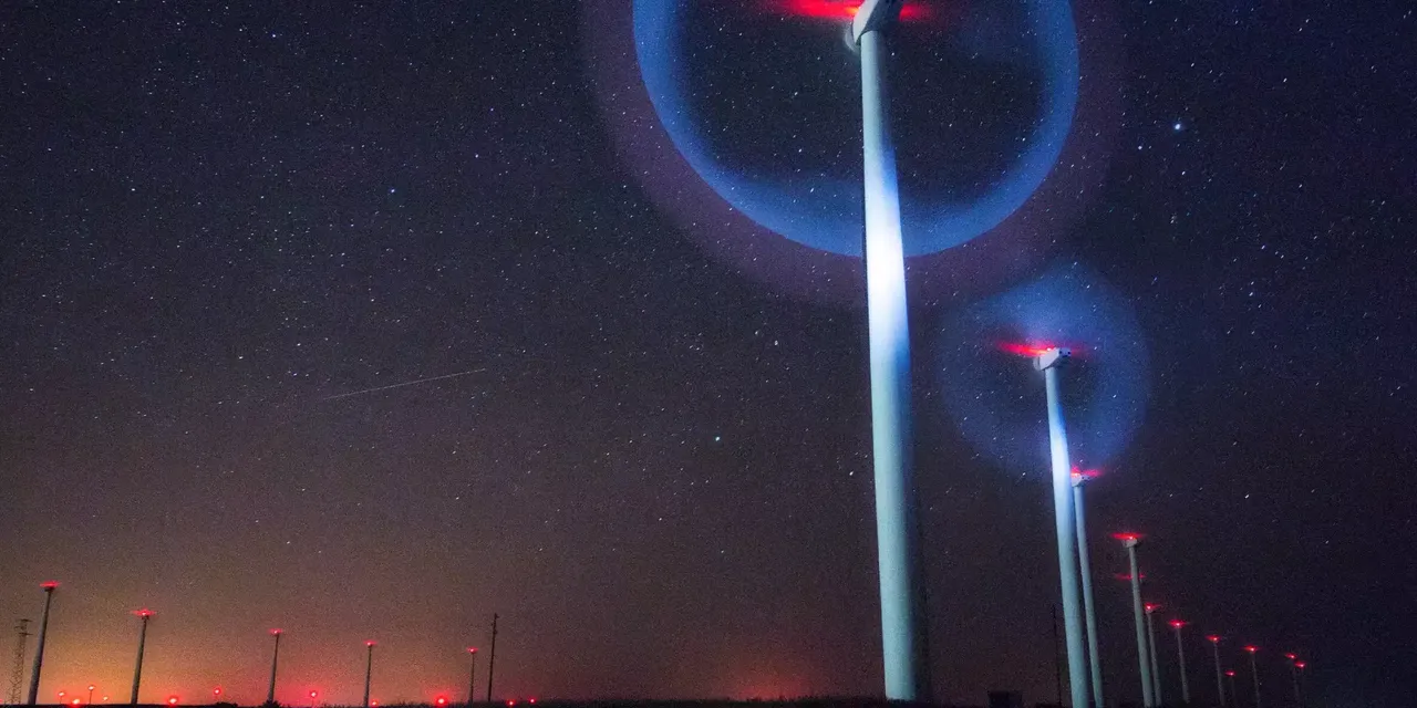 Es wird das nächtliche Blinken von Windkrafträdern in einem Windpark dargestellt.