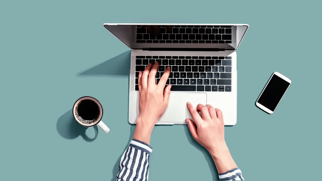 Laptop auf pastellfarbenen Hintergrund mit zwei Armen auf der Tastatur