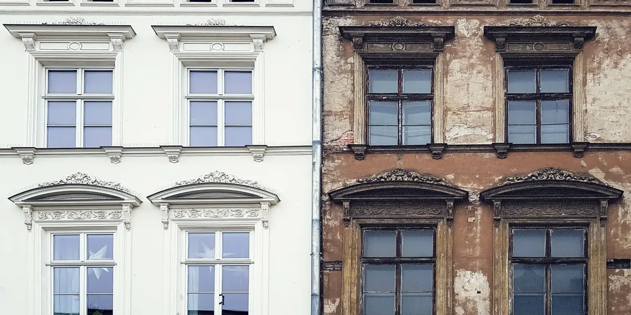 Es wird zur Veranschaulichung von Gebäudesanierung auf der linken Seite eine Fassade eines frisch renovierten Gebäudes gezeigt und als Kontrast auf der rechten Seite in unmittelbarer Nachbarschaft eine marode bröckelnde Gebäudefassade, die renovierungsbedürftig erscheint.