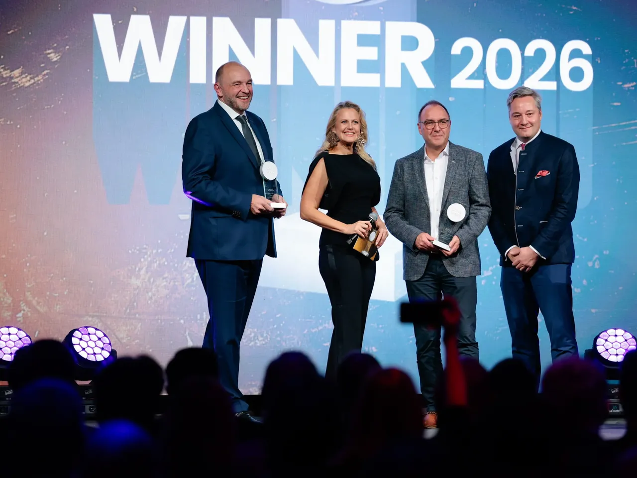 Es werden im Rahmen der Scope Award-Verleihung 2026 auf der Bühne mehrere Personen dargestellt, unter anderem Moderatorin Barbara Schöneberger und Commerz Real Vorstandsmitglied Dirk Schuster.