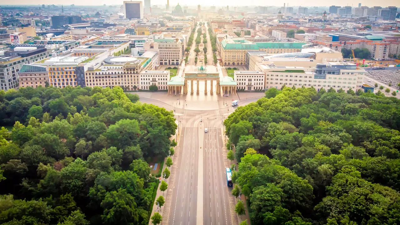 Es wird eine Übersicht über die Stadt Berlin dargestellt, im Vordergrund das Brandenburger Tor. 