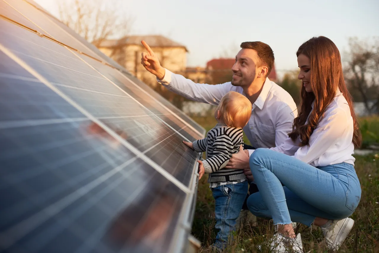 klimaVest: Eine
  Familie schautt sich ein Solarpanel an.