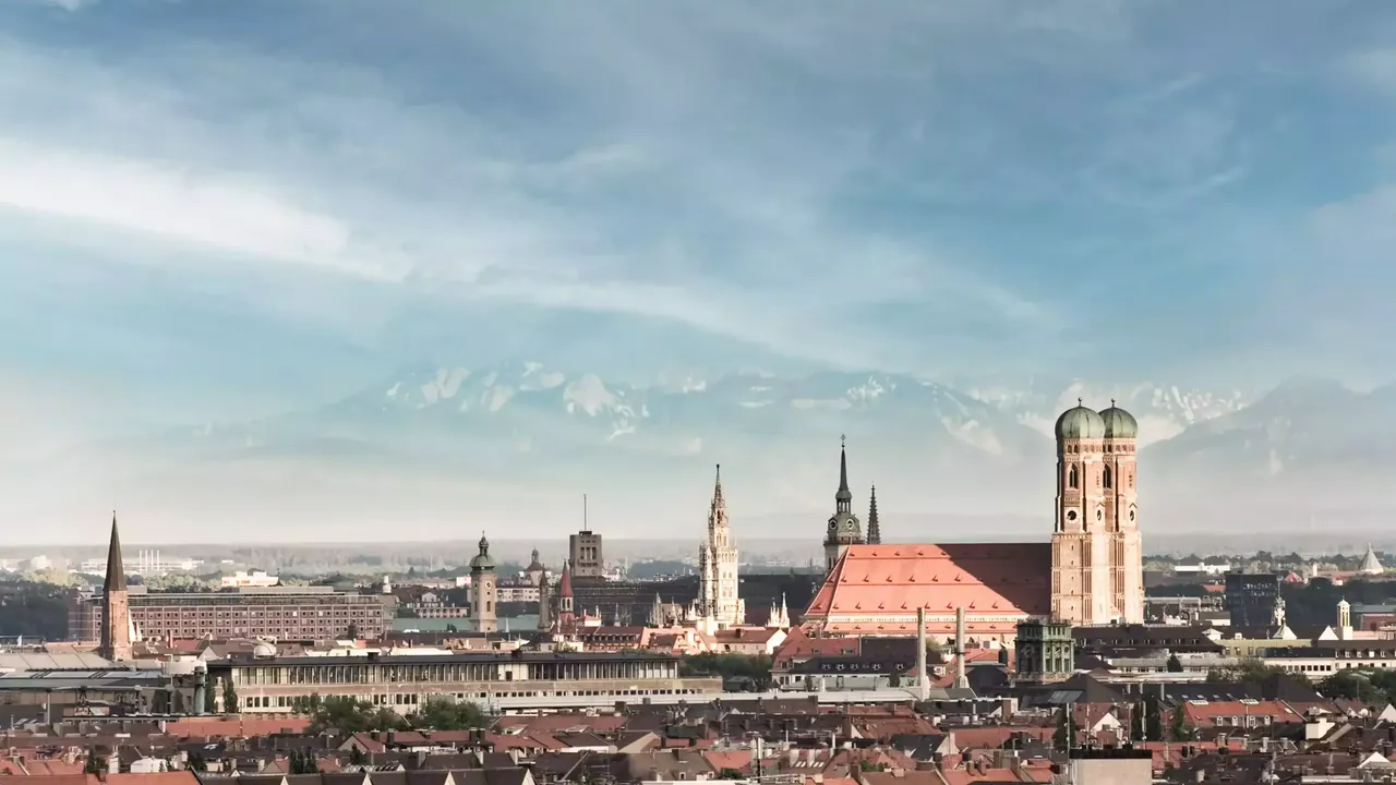 Übersicht über den hausInvest Standort München im Hintergrund mit Alpenpanorama