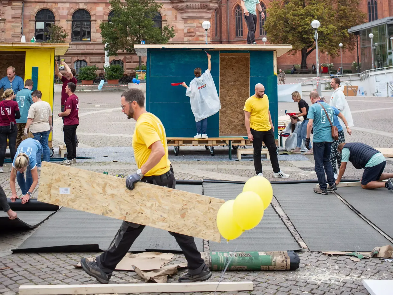 Commerz Real Mitarbeiter bauen in Teamarbeit Little Home Obdachlosen-Unterkünfte