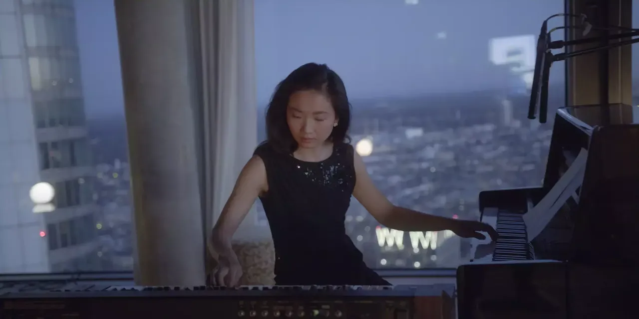 hausInvest Immobilie Omniturm bei Nacht von Innen mit einer Piano-Spielerin bei der Aufnahme für den Kampagnenfilm 50 Jahre hausInvest