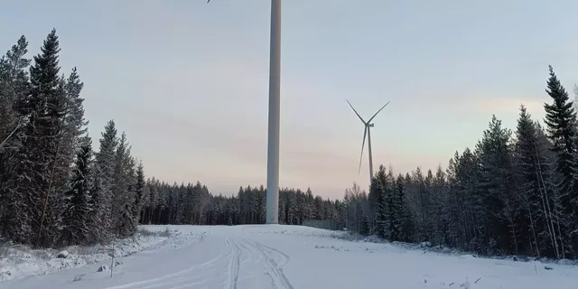 In einer Schneelandschaft wird die Außenansicht von zwei Windrädern des klimaVest Windparks Fennica in Finnland abgebildet.