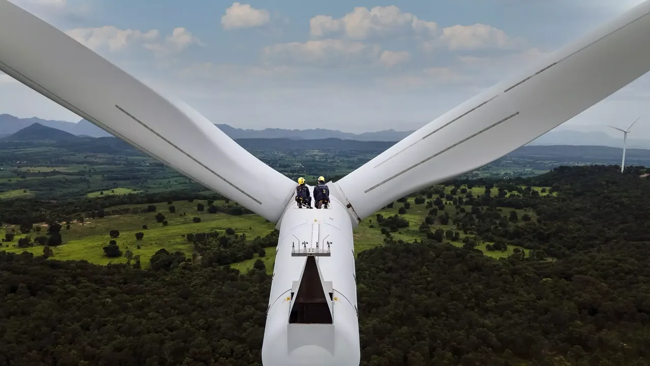 klimaVest: Zwei Arbeiter sitzen auf einem Windrad. Sie tragen gelbe Helme und Klettergurte. Sie sitzen in der Wartungsluke.