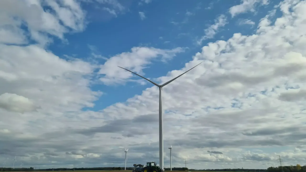 Aufnahme von einem
  Windrad in der Frontale im klimaVest-Asset: Windpark Heinsberg mit davor
  geparktem Traktor.