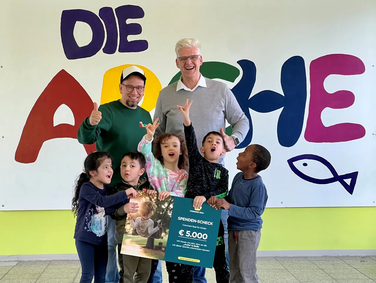 Es wird die Spendenübergabe im Rahmen der Aktion CR für Kinder in der Arche Berlin dargestellt