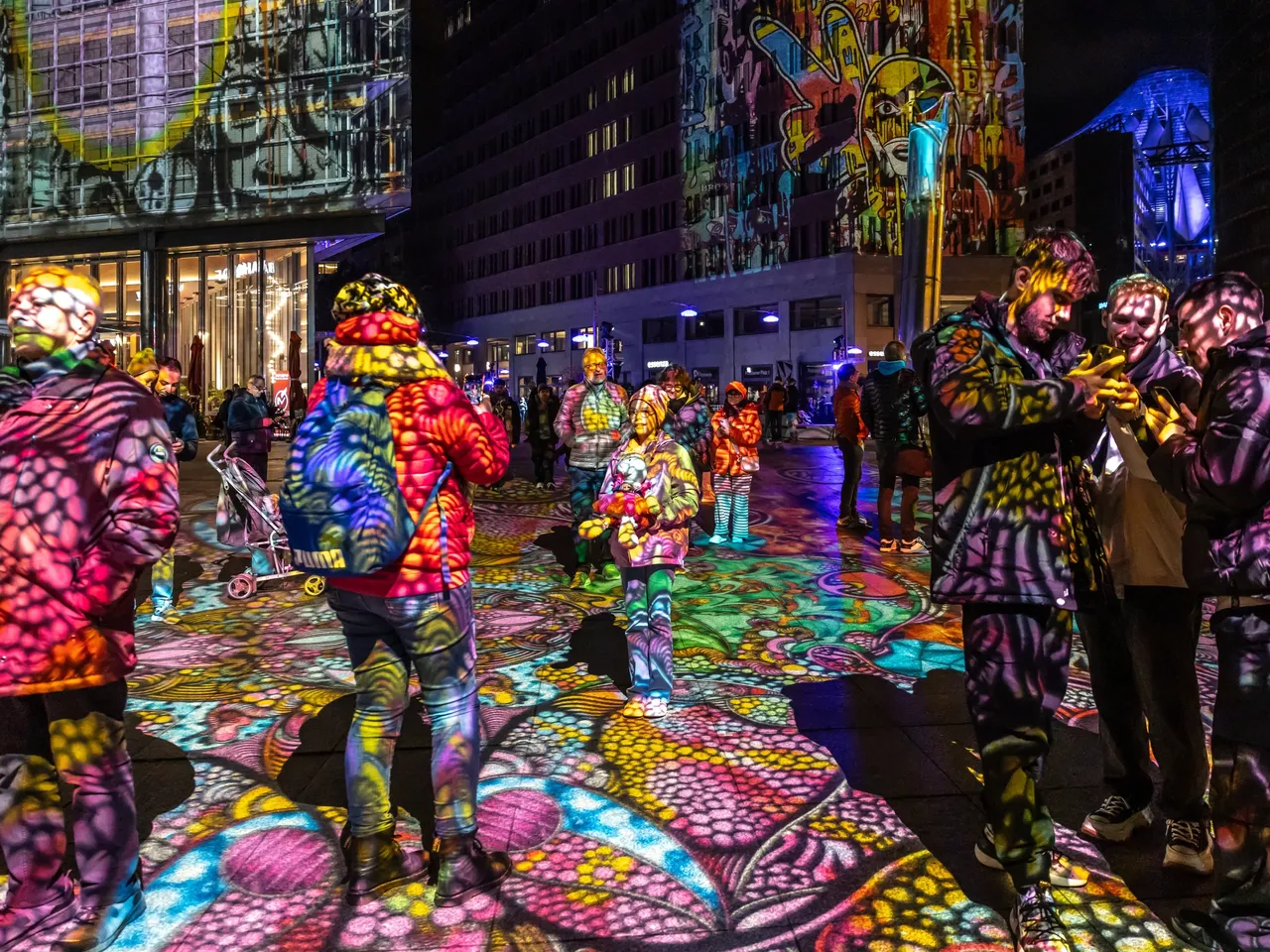 Es wird der Potsdamer Platz in Berlin dargestellt, der neben vielen anderen Gebäuden und Wahrzeichen während des sogenannten Festival of Lights spektakulär illuminiert wird.